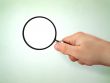 male hand holding magnifying glass