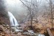 waterfall in foggy autumn forest