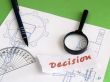 Decision, magnifier, pencil on draught