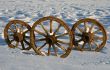 Three wooden wheels in a snow floor.