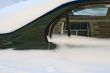 Car in the deep snow reflecting buildings around