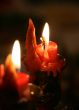 red candle flaming upon dark background