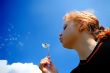  woman blows on  dandelion