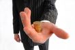  businessman holds  pile of coins