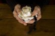 old hands with white rose and cross