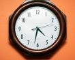 Modern clock on orange wall