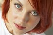 beautician is doing make-up to red-haired woman
