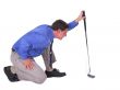 Man with blue shirt aiming over putter