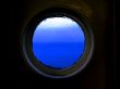 Blue sea and sky through rainy porthole