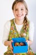 Young girl presenting a box with painted eggs