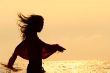 girl silhouette on golden sunset sky background