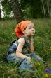 little girl sit on grass in forest
