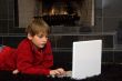 Boy at Fireplace on Computer.