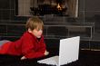 Boy at Fireplace on Computer.