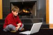 Boy at Fireplace on Computer.