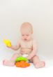 Little baby playing with toys over light gray background