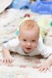 Playful child crawling on the carpet in living room