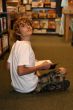 young teen boy sitting in bookstore reading