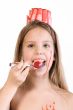 Blond child with desert on her head eating