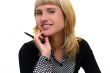 young woman with pen is smiling in office