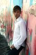 youth leans against graphiti wall