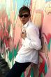 youth leans against graphiti wall