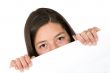 girl peeping over a white card