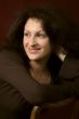 Portrait of the young smiling woman on a dark background.