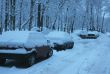 Snow covered cars parked along the road