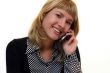 young woman with mobile phone is smiling in office