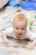 Playful child crawling on the carpet in living room