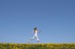 Happy girl running in dandelion field