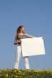 Young woman holding blank cardboard with copyspace