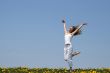 Smiling girl dancing in dandelion field