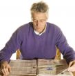 Elderly man is reading newspapers