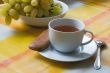 Cup of tea with a biscuit and grapes