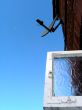 Dish-shaped antenna and window against sky