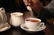 man put sugar into cup of tea