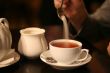 man put sugar into cup of tea