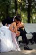 Newlyweds kissing on park bench