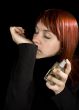 Girl smelling parfume from her hand