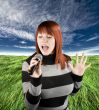 Redhead girl singing karaoke on microphone