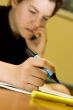 Student girl biting nails while studying