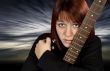 Sad girl protecting her guitar
