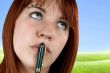 Cute girl with pen on her lips