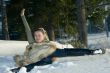 The young beautiful girl laying on snow in wood.