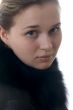 Young beautiful girl in a fur jacket on a white background.