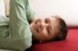 Happy teenager lie on red sofa at home