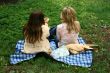 two girls sitting on the grass