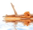 legs of girl with orange towel on white sand 2
